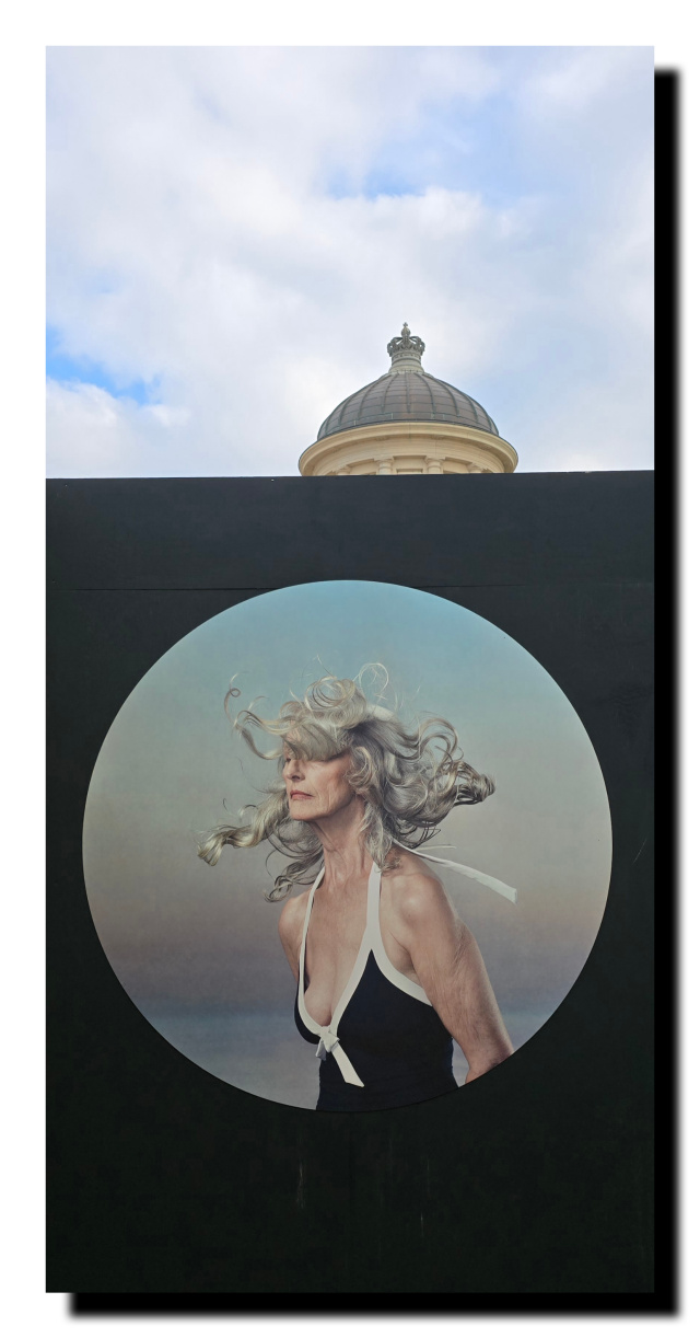 C'est la biennale de la photo à Ostende. Cette photo est en rond, dans un rectangle noire. Elle est le long de la promenade au dessus de la plage.
